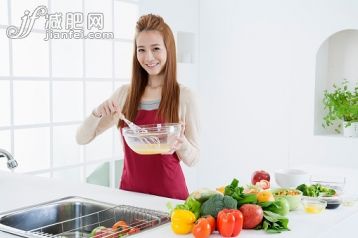 厨房,人,饮食,食品,生活方式_558968797_Young woman holding wire whisk and smiling at the camera,_创意图片_Getty Images China