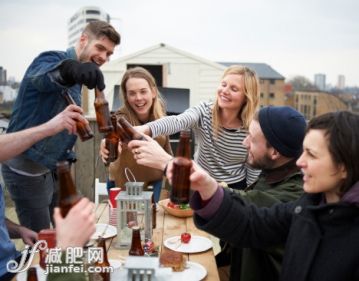 人,休闲装,城市,桌子,瓶子_168595519_Toasting drinks around table in urban roof garden._创意图片_Getty Images China